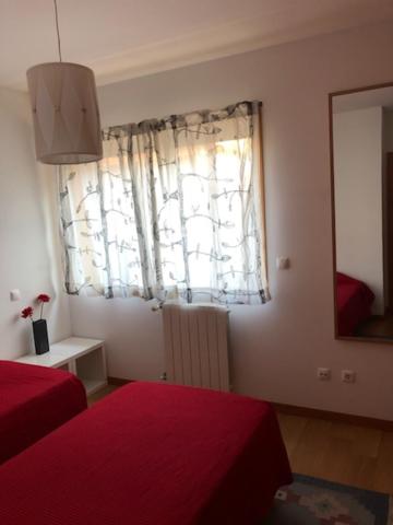a bedroom with a red bed and a window at InPorto in Porto