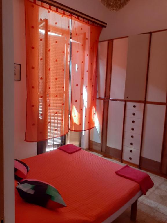 a bedroom with a red bed and a window at Il Pretoriano in Rome