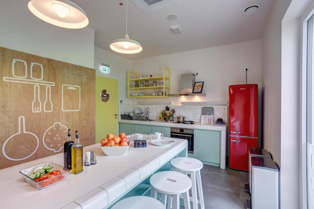 a kitchen with a red refrigerator and some stools at MEININGER Hotel Heidelberg Hauptbahnhof in Heidelberg