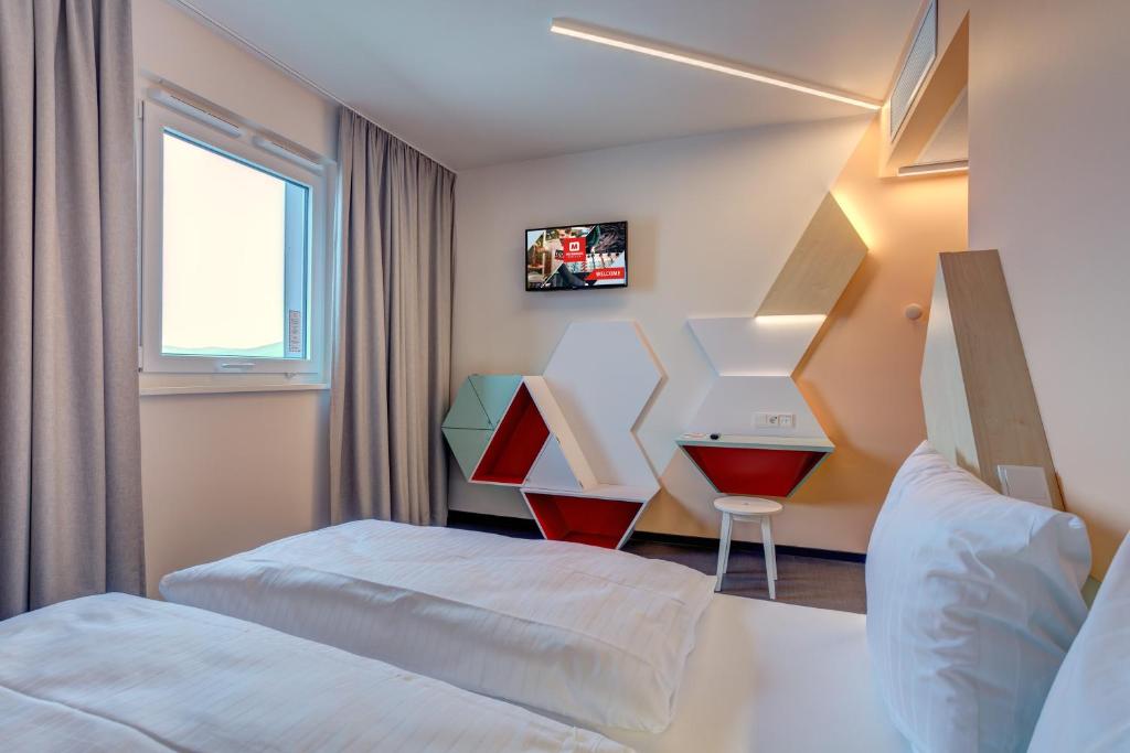 Postel nebo postele na pokoji v ubytování MEININGER Hotel Heidelberg Hauptbahnhof