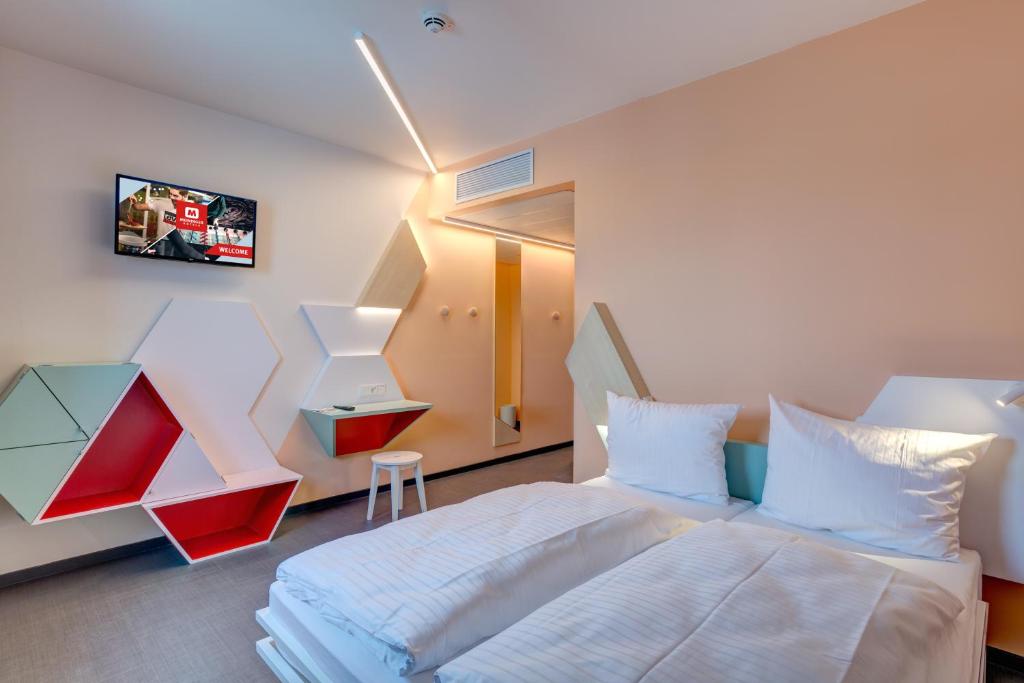 Postel nebo postele na pokoji v ubytování MEININGER Hotel Heidelberg Hauptbahnhof