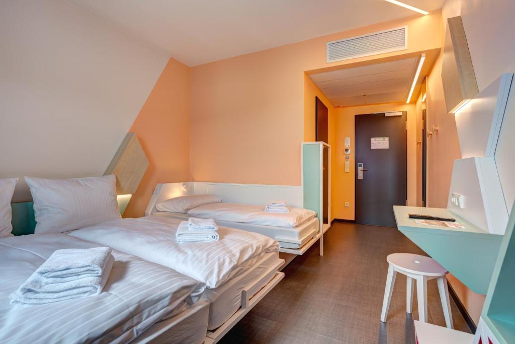 Postel nebo postele na pokoji v ubytování MEININGER Hotel Heidelberg Hauptbahnhof