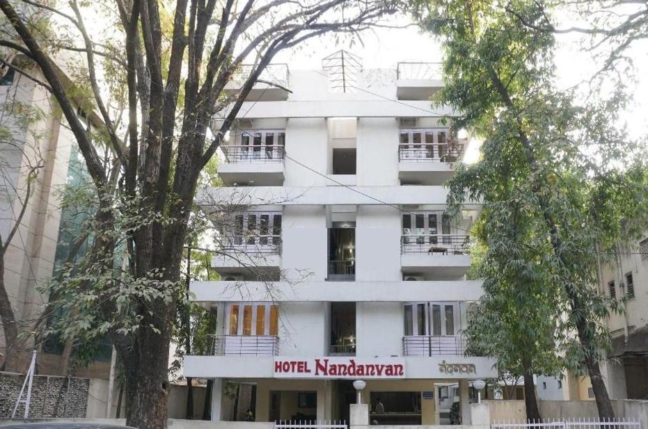 Un bâtiment blanc avec un panneau. dans l'établissement Hotel Nandanvan Annexe, à Pune