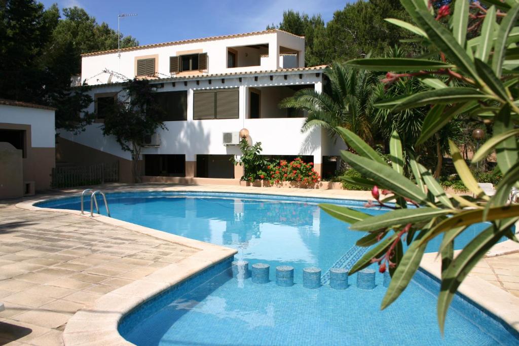 a villa with a swimming pool in front of a house at Viviendas Turísticas Vacacionales Allida in Playa Migjorn