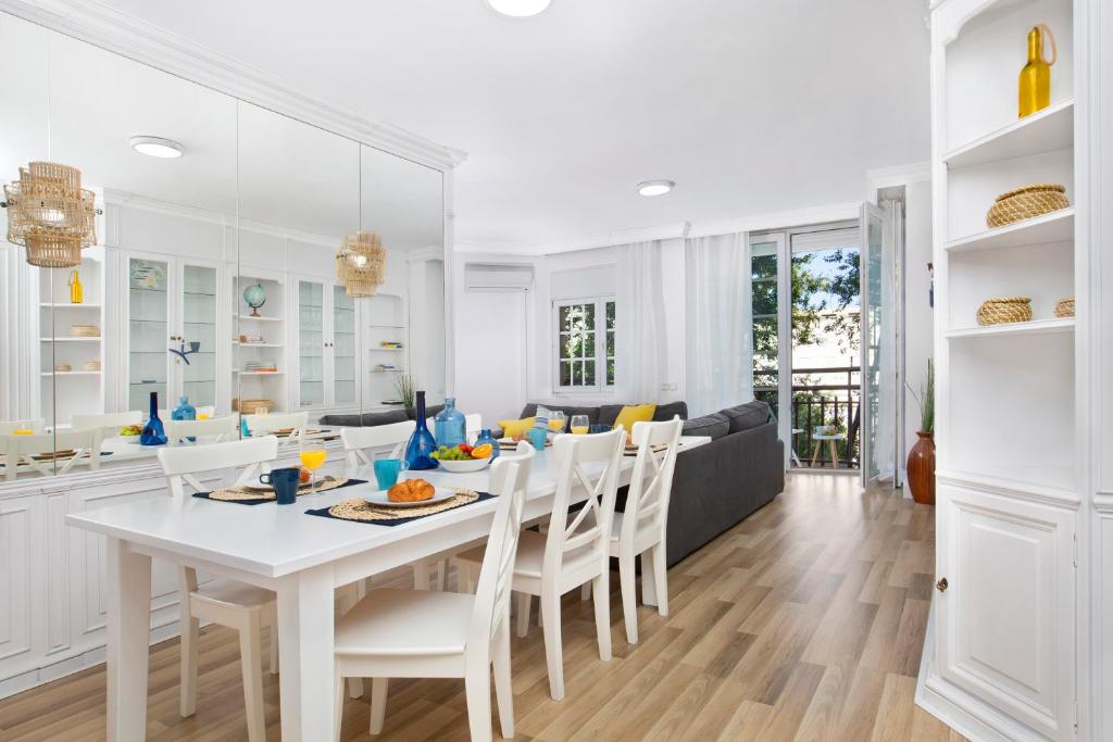 cocina y comedor con mesa blanca y sillas en Stay U-nique Apartments Sardenya II, en Barcelona