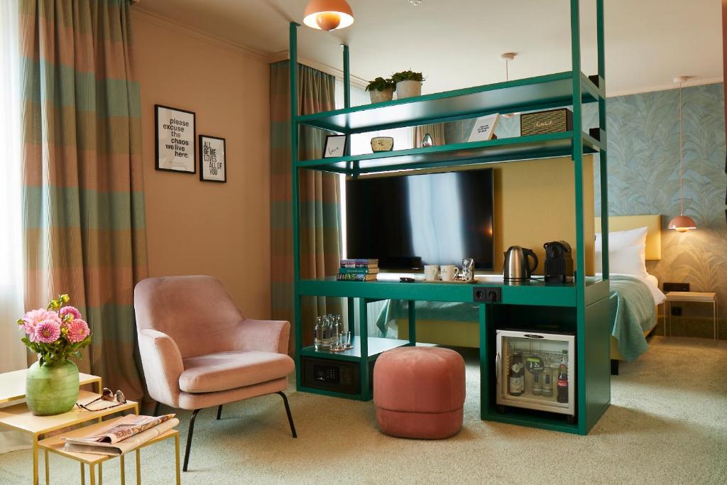 una sala de estar con un estante verde y una silla en Hotel Metropol by Maier Privathotels, en Múnich