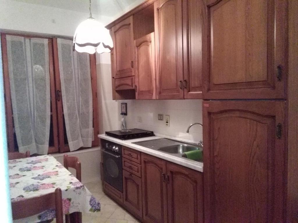 eine Küche mit Holzschränken und einem Waschbecken in der Unterkunft Casa Margherita in Santo Stefano al Mare