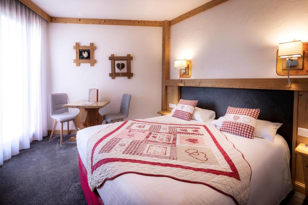 ein Hotelzimmer mit einem Bett und einem Tisch in der Unterkunft Hotel Le Littoral in Évian-les-Bains
