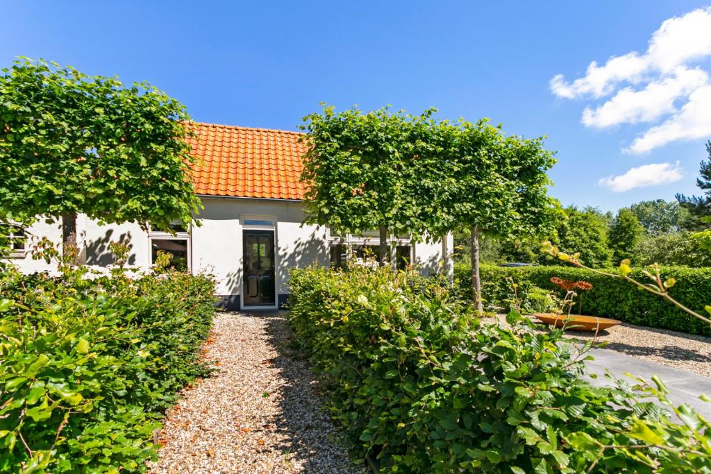 アウウドルプにあるHoliday home Dijkstelweg 30 - Ouddorp with terrace and very big garden, near the beach and dunes - not for companiesのオレンジ色の屋根の白い家