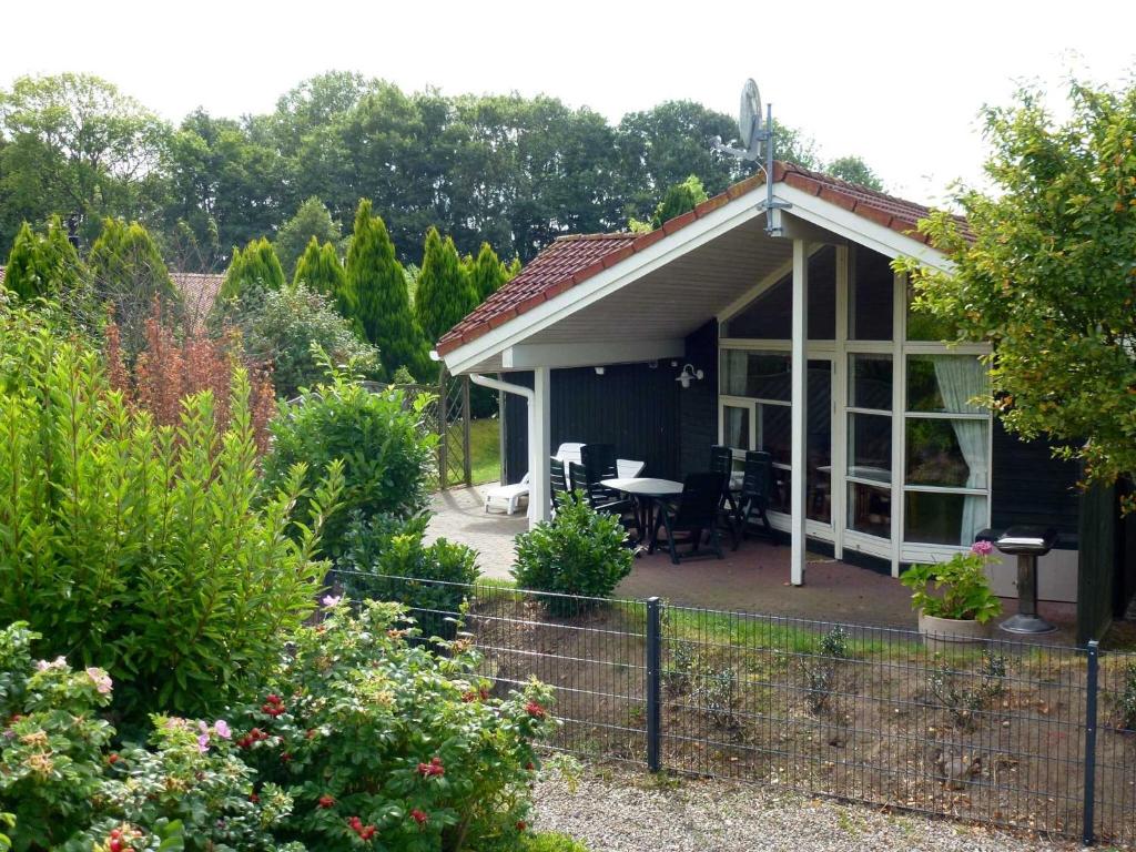 a cottage with a table and chairs in a garden at Ferienhaus Strandmuschel in Schönhagen