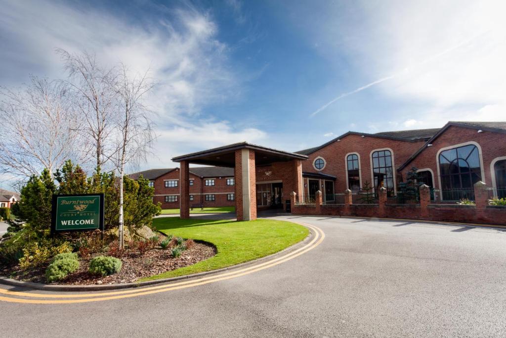 a brick building with a sign in front of it at Burntwood Court Hotel in Barnsley