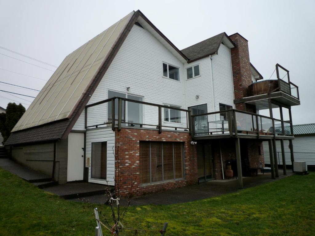 una gran casa blanca con techo de gambrel en Fireflies Bed & Breakfast, en Campbell River