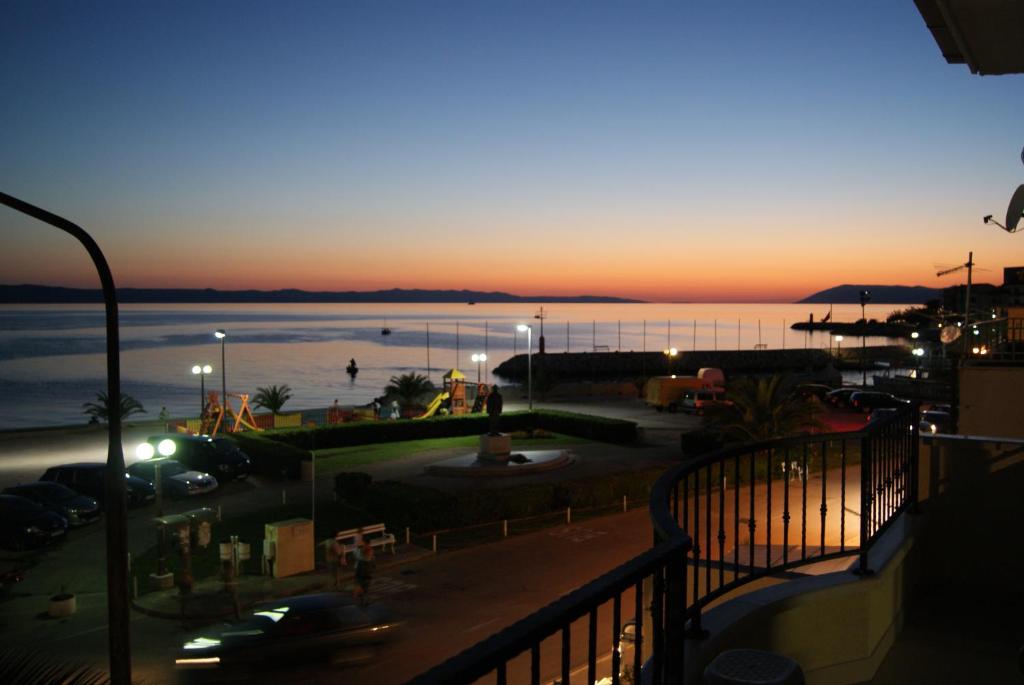 a view of the ocean at sunset from a balcony at Apartments Lena in Podgora