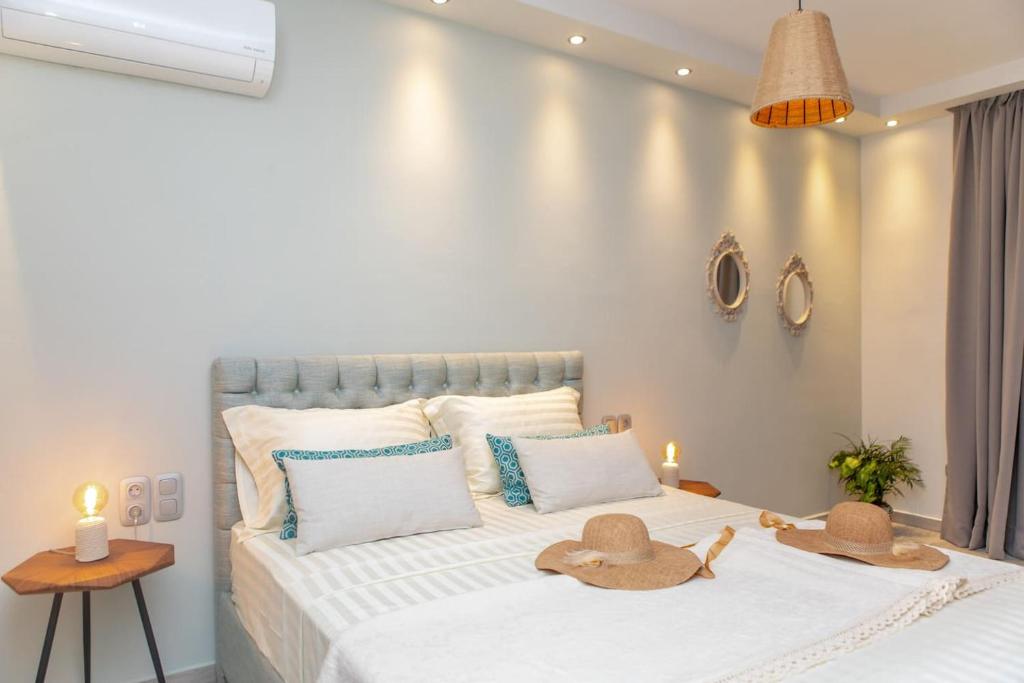 una camera da letto con un letto con due cappelli sopra di 100 Steps - Harmony a Naxos Chora