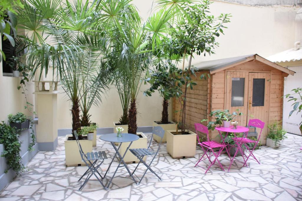 a patio with tables and chairs and a small shed at Est Hotel in Paris