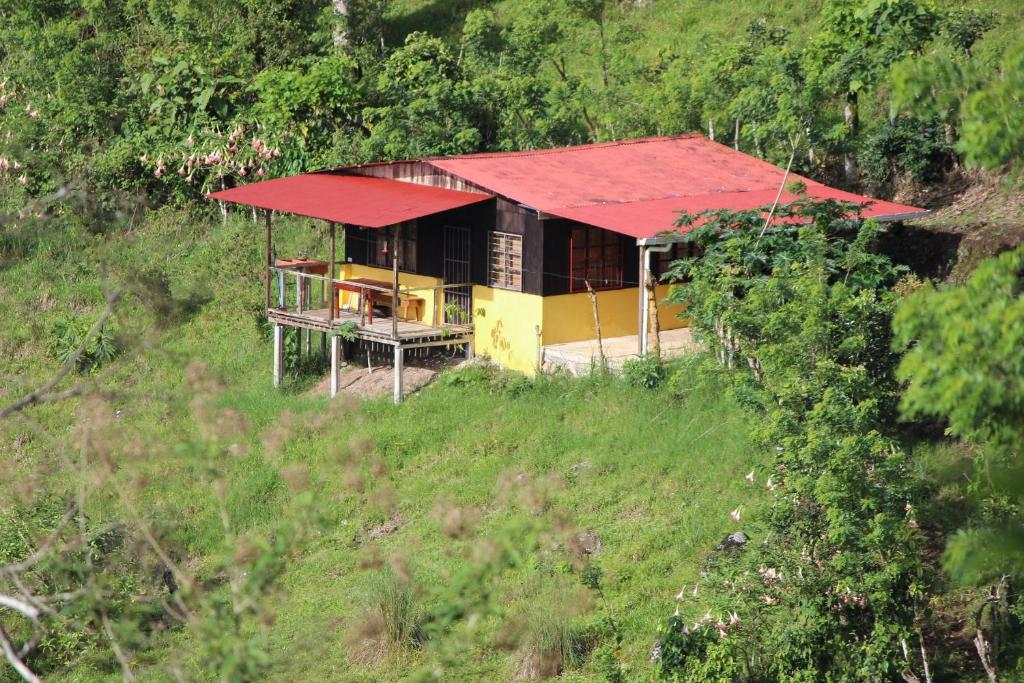 ein Haus mit rotem Dach auf einem Hügel in der Unterkunft Casa Colibrí in La Suiza