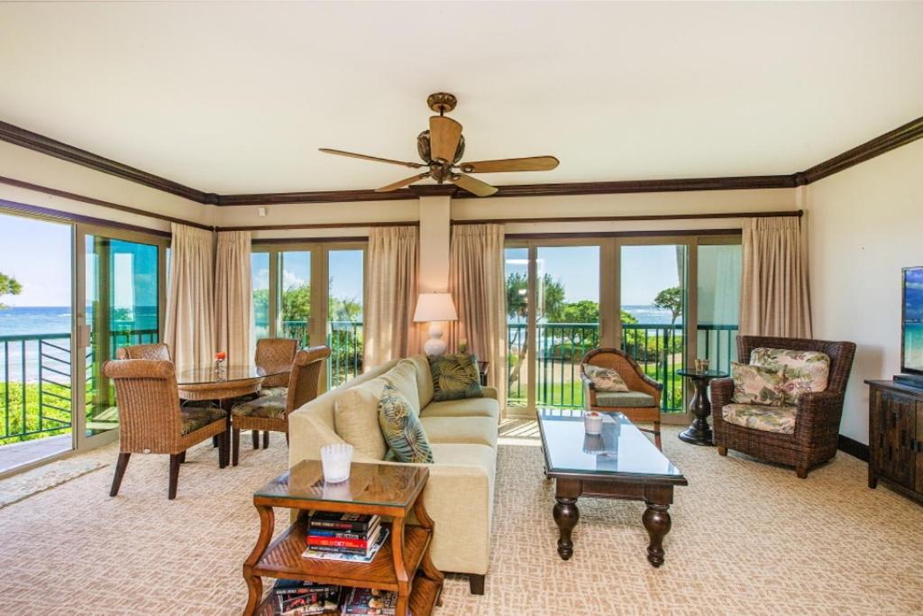 a living room with a ceiling fan and a couch at Waipouli Beach Resort VIP Ocean Front Penthouse Villa! AC Pool in Kapaa