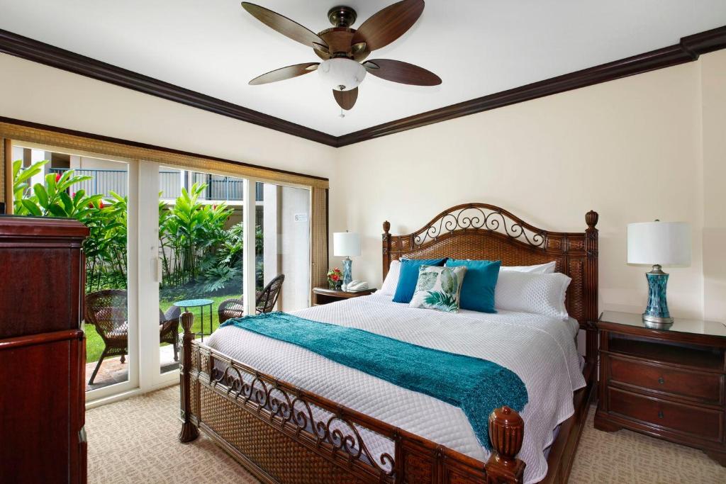 a bedroom with a bed and a ceiling fan at Waipouli Beach Resort Beautiful Luxury Ground Level Garden View AC Pool! in Kapaa