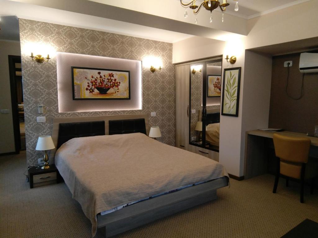 a bedroom with a bed and a table and a mirror at La Cristina in Slatina