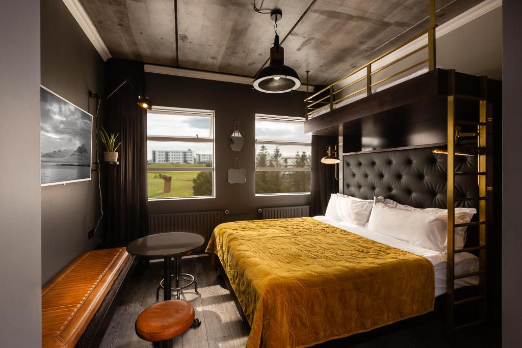 een slaapkamer met een bed, een tafel en een stoel bij R13 - A Townhouse Hotel in Reykjavík