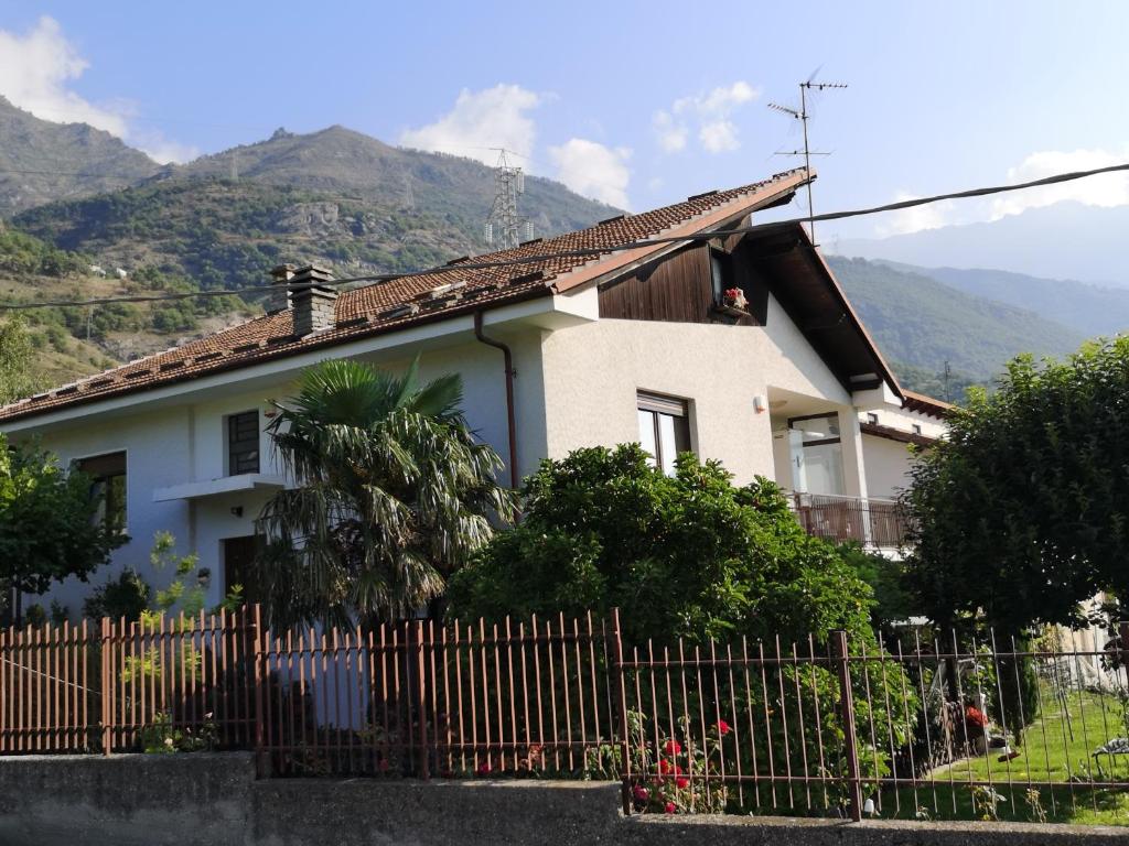 una casa con recinzione e montagne sullo sfondo di La Casa Dei Nonni a Bussoleno