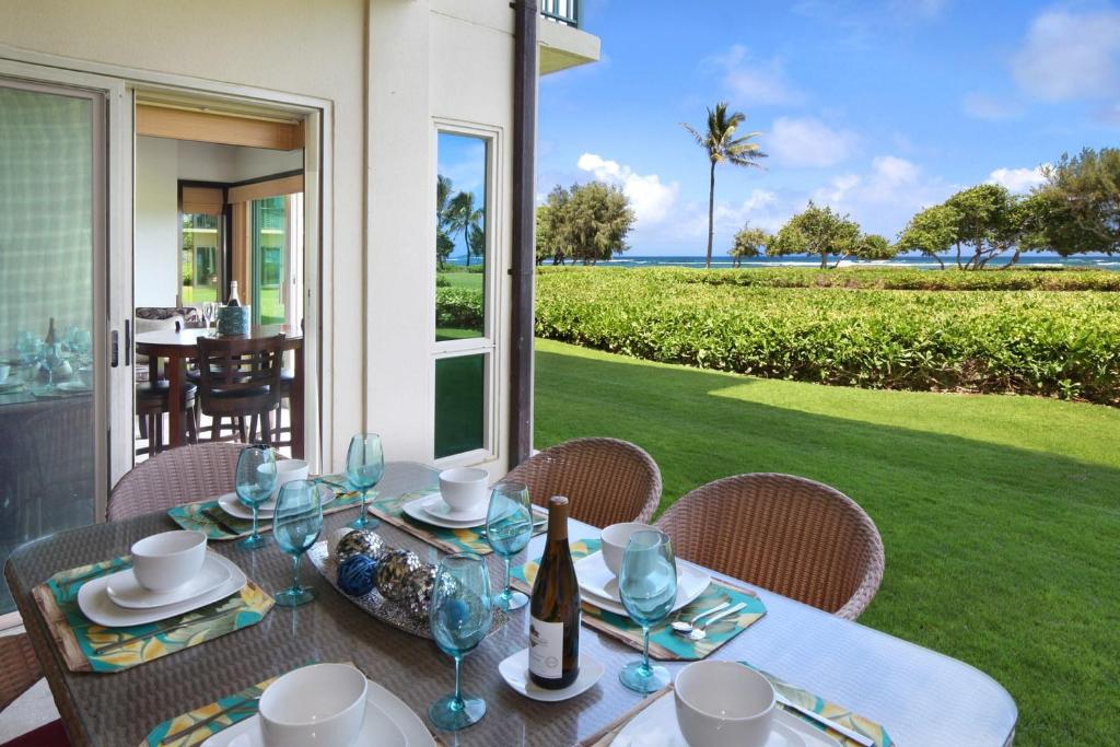 a dining table with a view of the ocean at Waipouil Beach Resort Gorgeous Ocean Front Condo! Sleeps 8 AC Pool in Kapaa