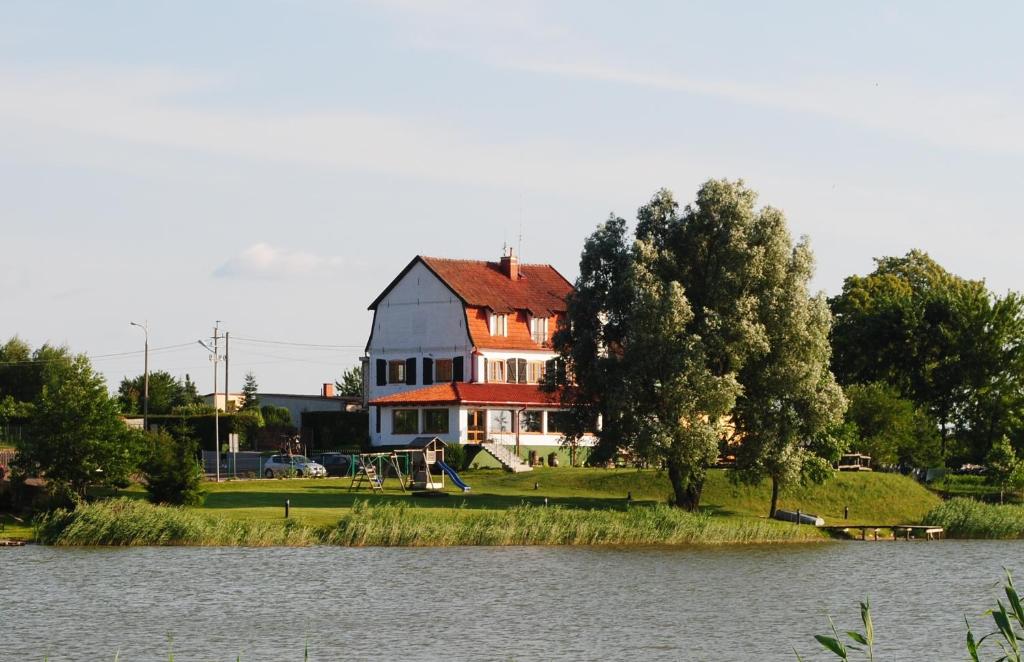 a house on an island in the middle of a lake at Karczma Stary Młyn in Giżycko