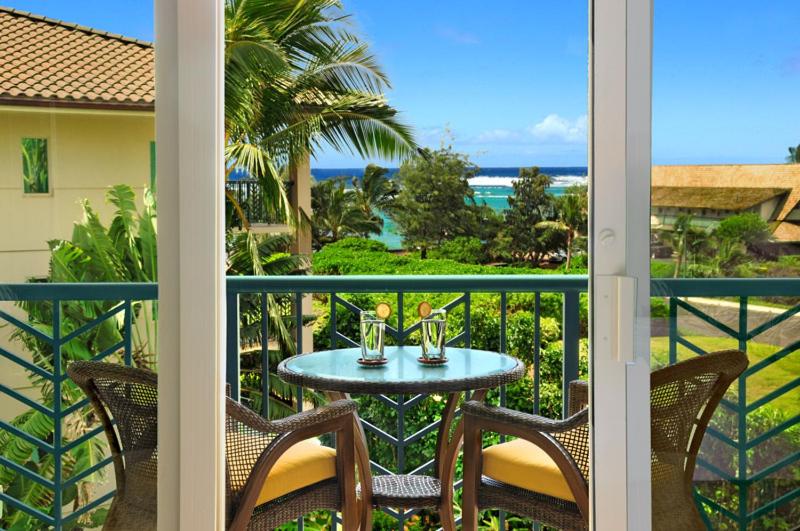una mesa en un balcón con vistas al océano en Waipouli Beach Resort Penthouse Beautiful Oceanview Aloha! AC Pool, en Kapaa
