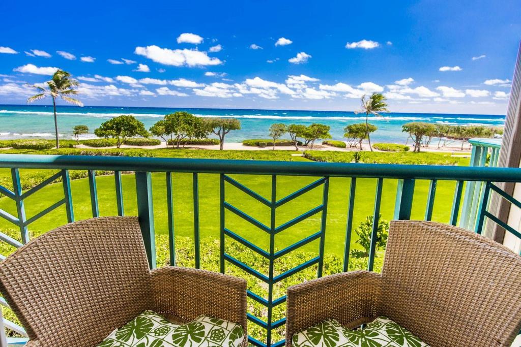 2 stoelen op een balkon met uitzicht op de oceaan bij Waipouil Beach Resort Waipouli Beach Resort Gorgeous Luxury Oceanfront! AC Pool in Kapaa