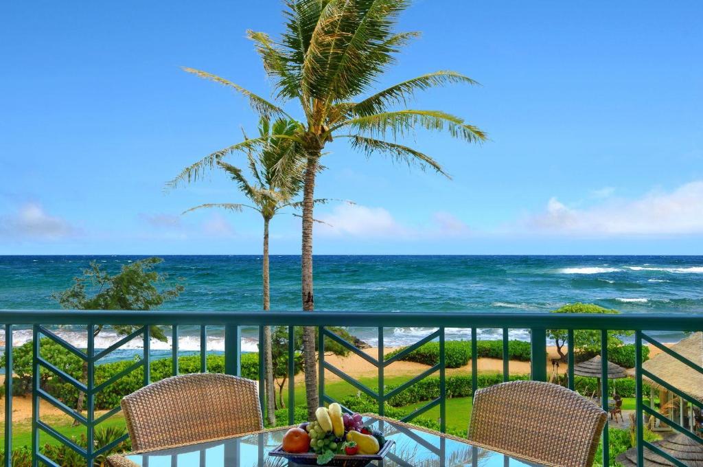 una mesa con un bol de fruta en el balcón con vistas al océano en Waipouli Beach Resort Exquisite Luxury VIP Oceanfront Condo! AC Pool, en Kapaa