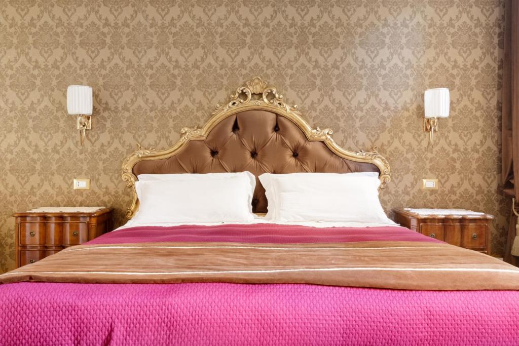 um quarto com uma cama grande e um cobertor rosa em Cà Nova em Veneza