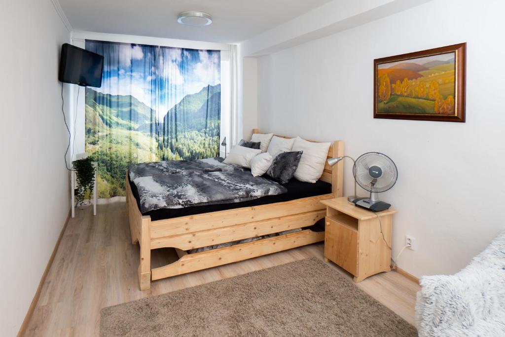 una camera con letto in legno e dipinto a parete di Útulný apartmán s pekným výhľadom na hory a Martin