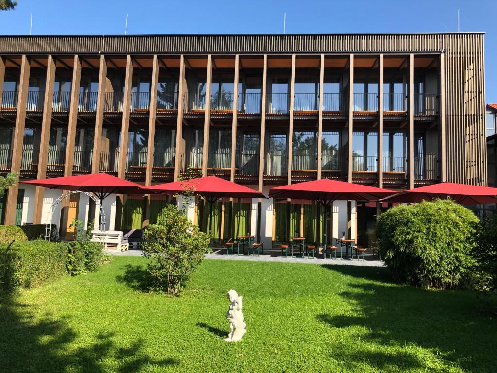 un perro sentado en el césped frente a un edificio en Gasthof-Hotel Höhensteiger, en Rosenheim