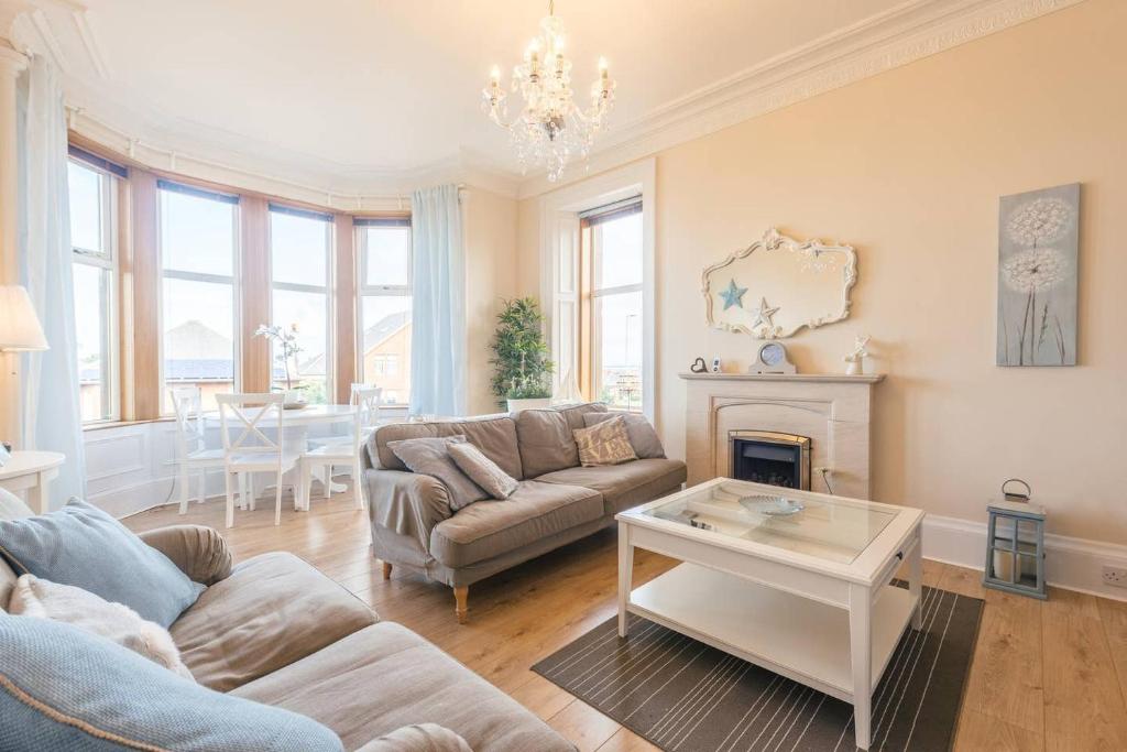 uma sala de estar com um sofá e uma mesa em Arran View em Prestwick