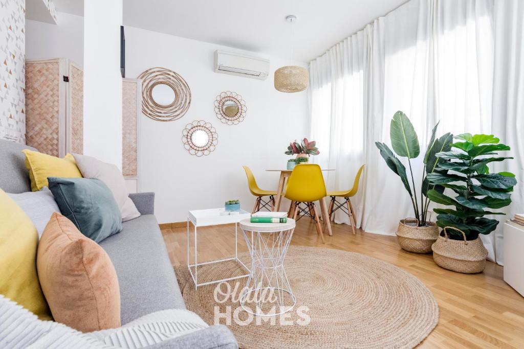 een woonkamer met een bank en een tafel met stoelen bij Go Madrid Apartments by Olala Homes in Madrid