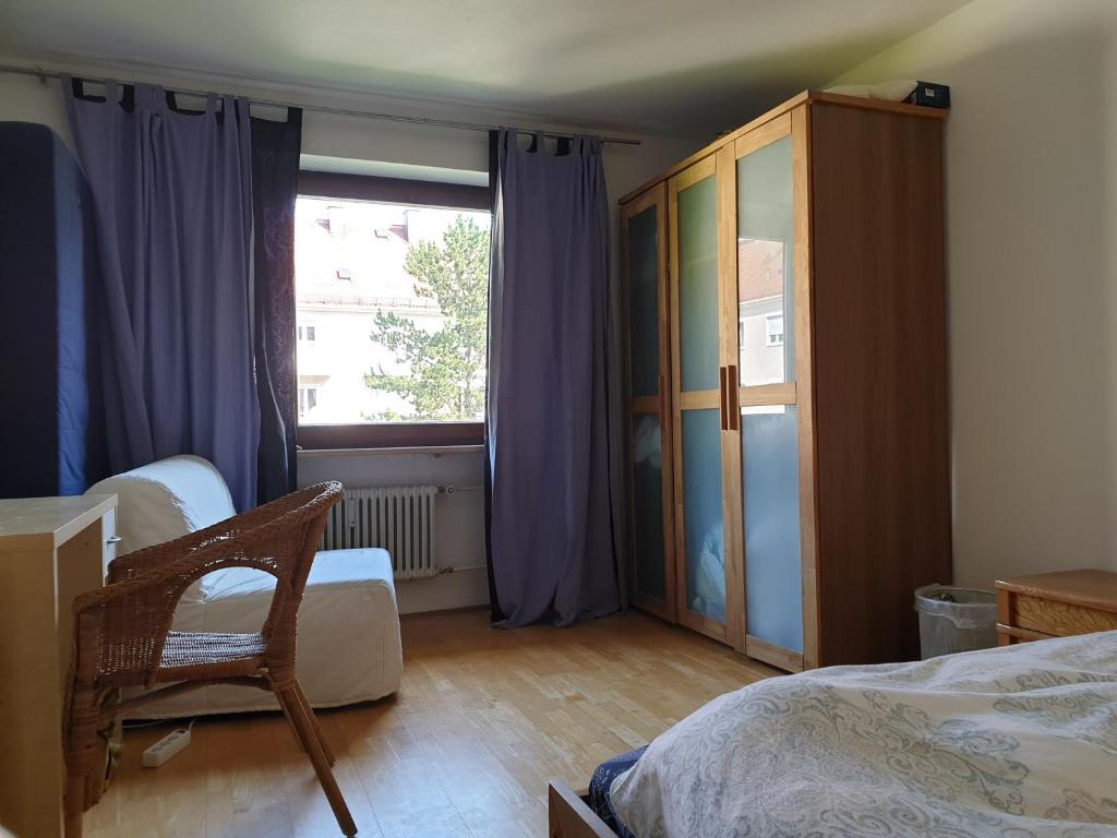 ミュンヘンにあるOktoberfestのベッドルーム1室(ベッド1台付)、紫色のカーテン付きの窓が備わります。