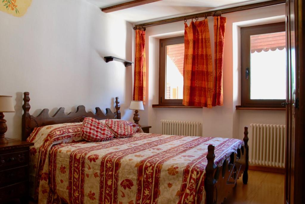 1 dormitorio con 1 cama con manta y 2 ventanas en CasAda en Nus