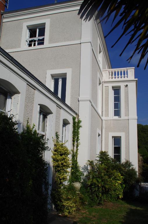 a white building with a tower on top of it at Maison Latour in Cholet