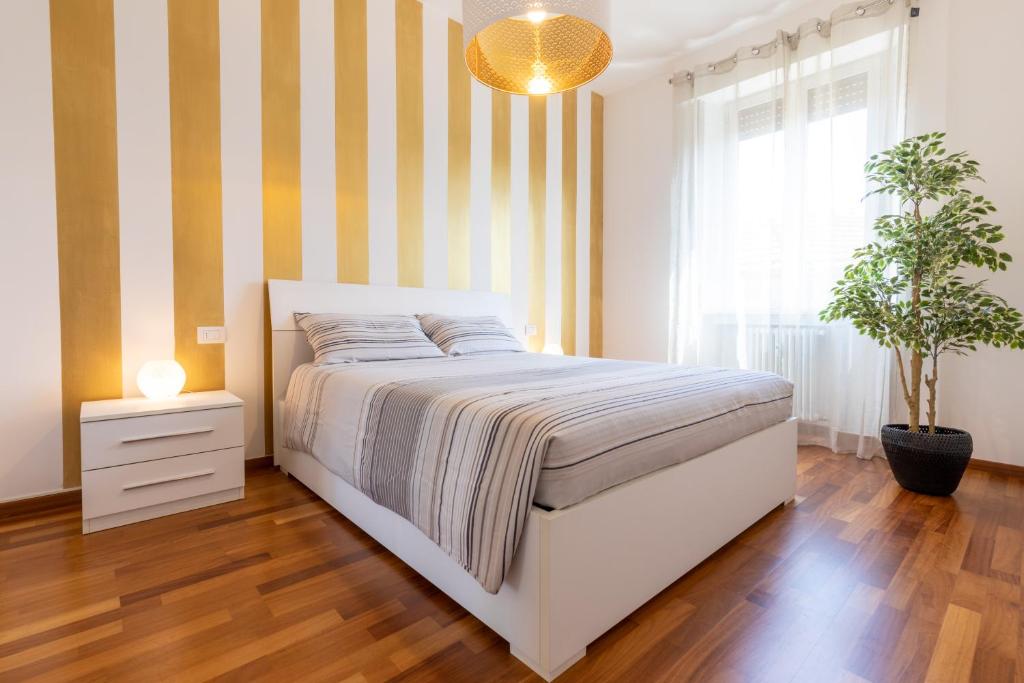 a bedroom with a bed with a striped wall at Golden House Milano in Milan