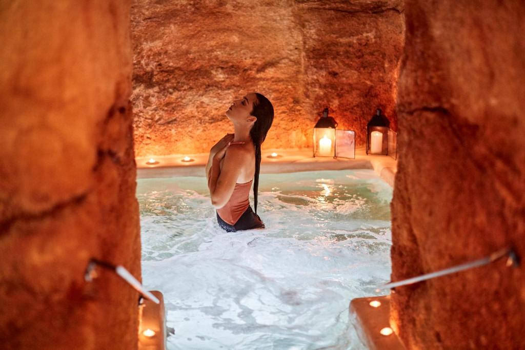 a woman is standing in a pool of water at Musae Relais & SPA in Polignano a Mare