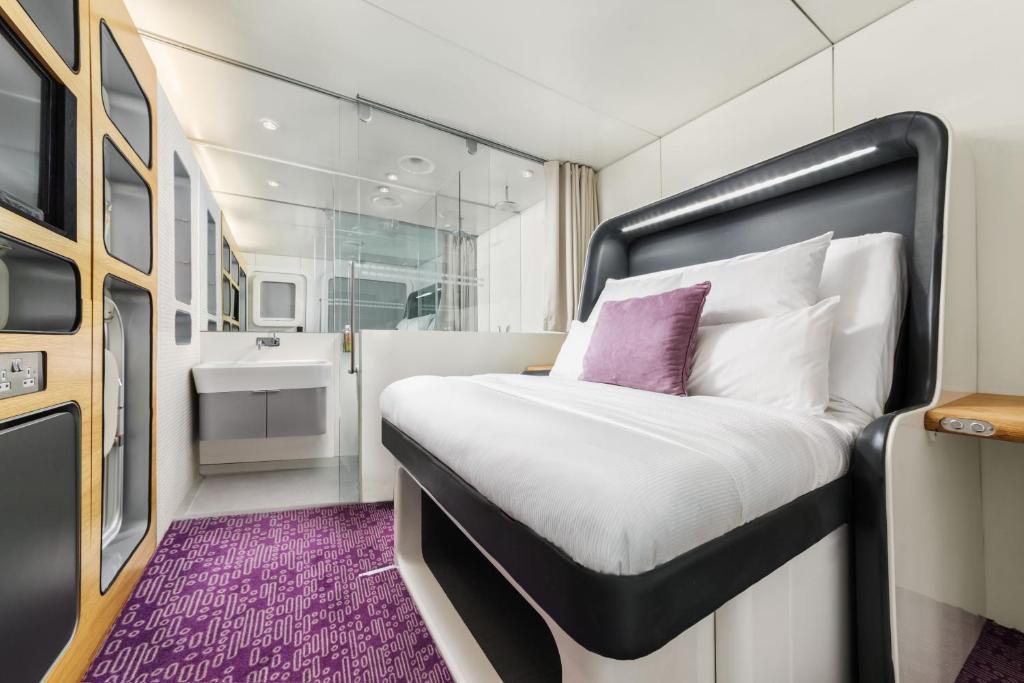 a bedroom with a bed and a bathroom at YOTELAIR Amsterdam Schiphol Transit Hotel in Schiphol