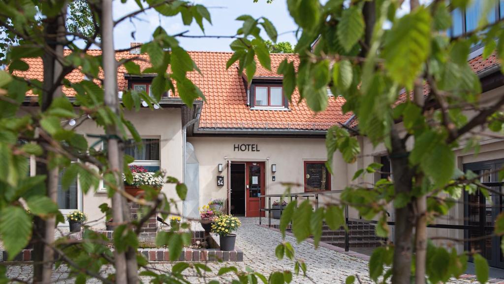 un edificio blanco con techo rojo en Landhotel Diana, en Teltow