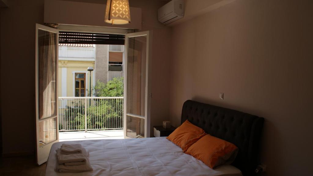 1 dormitorio con cama y ventana abierta en The Victoria Square Exceptional Apartments en Athens