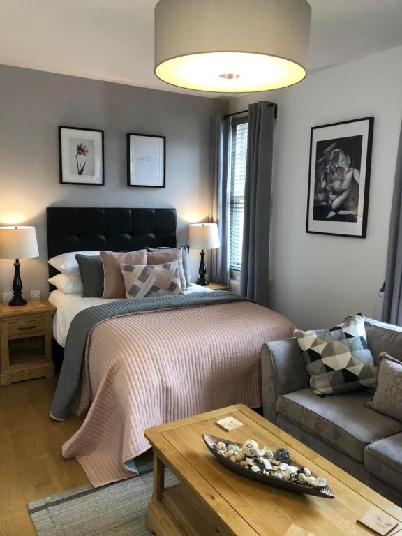 a bedroom with a bed and a couch and a table at The Larches in Wolverhampton