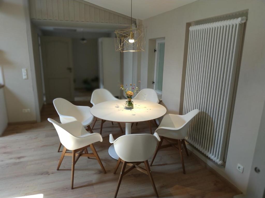 ein Esszimmer mit einem weißen Tisch und weißen Stühlen in der Unterkunft Annel's Liebelei in Radebeul