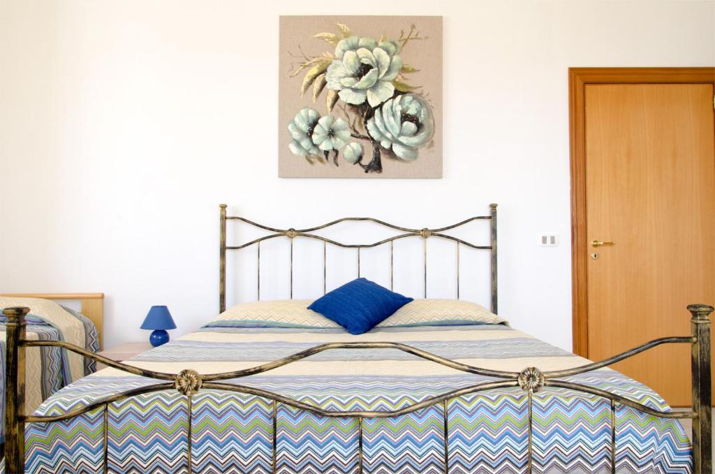 a bedroom with a bed with a blue and white blanket at Casa Campanina in Agropoli