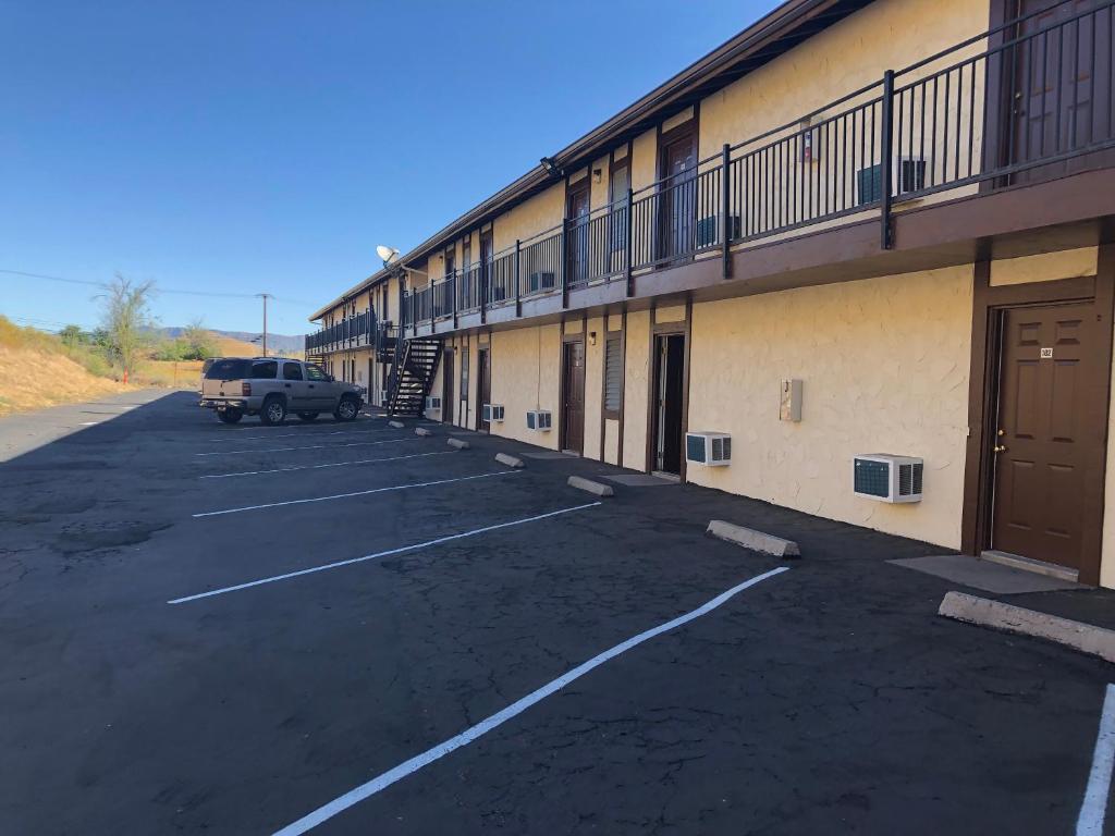 um carro estacionado num parque de estacionamento ao lado de um edifício em Golden Hills Motel em Tehachapi