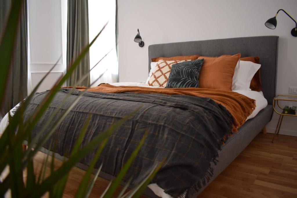 a bedroom with a bed with pillows on it at VOYA Apartments - a luxury oasis in the old town in Braşov