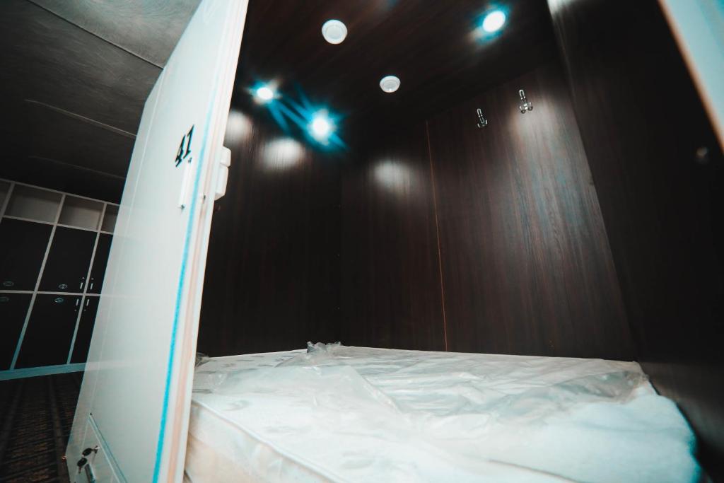 a surfboard sitting on top of a bed in a room at Capsule hotel TechnoCave in Bishkek