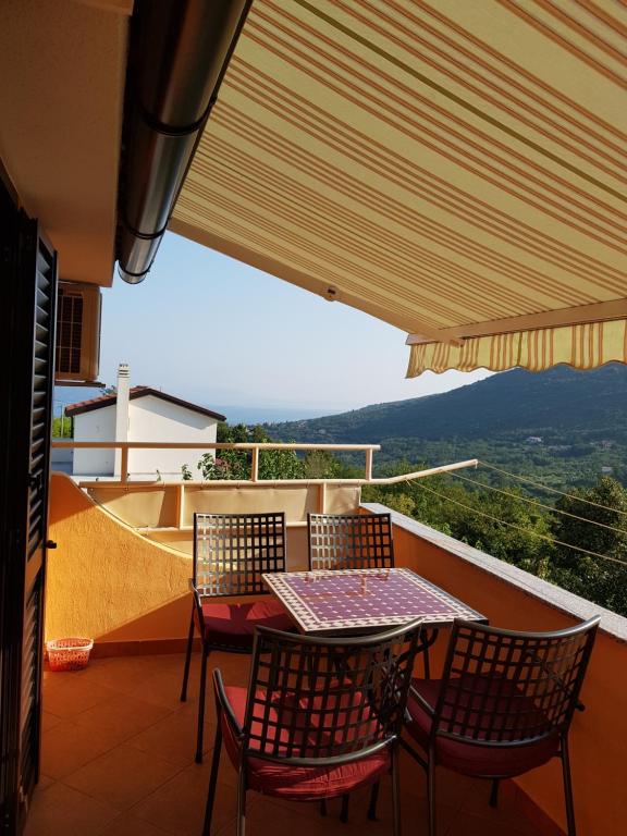 una mesa y sillas en un balcón con vistas en Diana Apartman, en Brseč